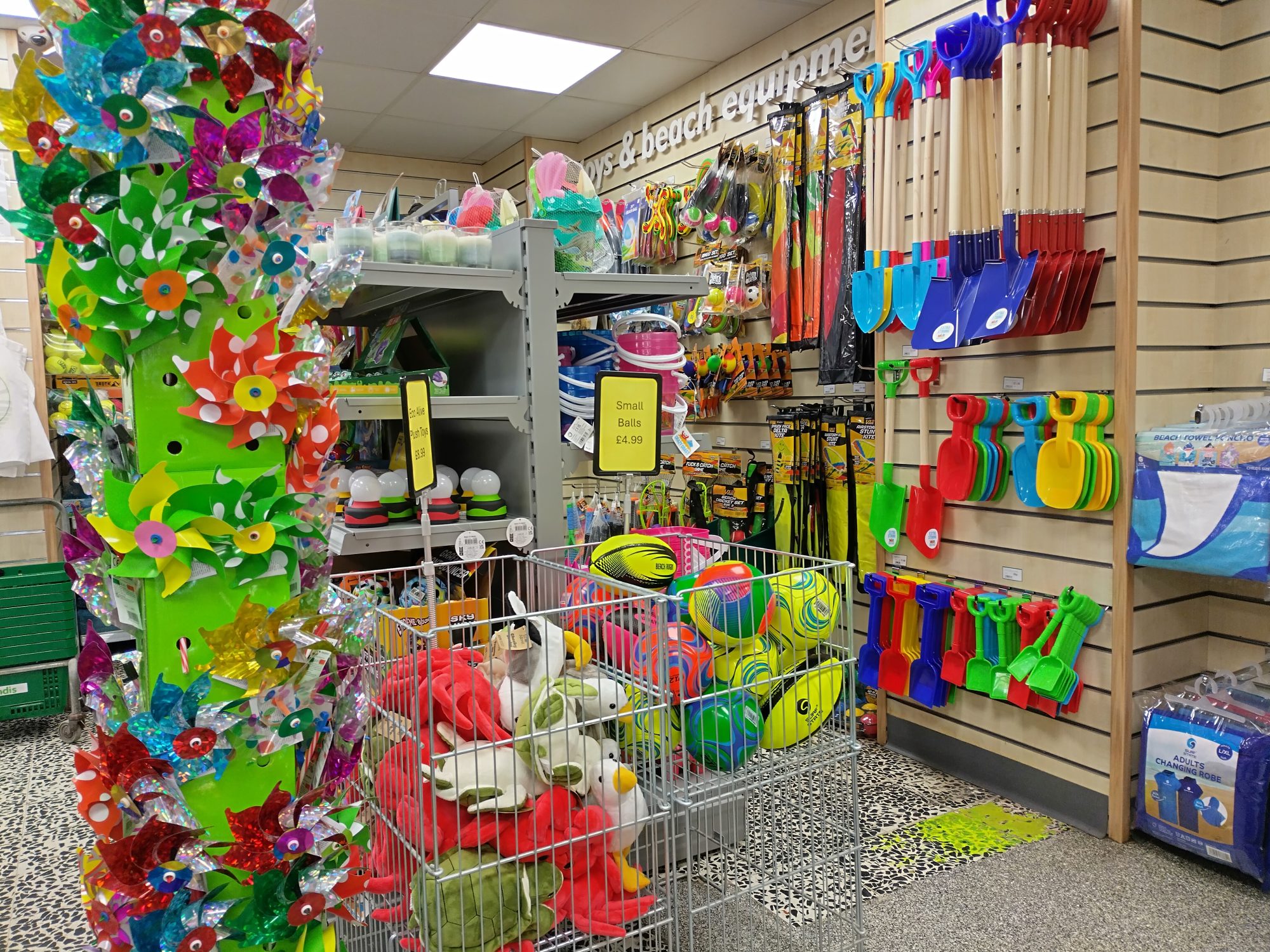 A photograph of a display of beach goods at Seaview Minimarket including spades, balls and windmills.